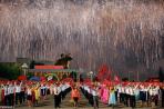 Fireworks explode over participants in a mass dance in the capital's main ceremonial square, a day after the ruling Workers' Party of Korea party wrapped up its first congress in 36 years, in Pyongyang, North Korea. REUTERS/Damir Sagolj
